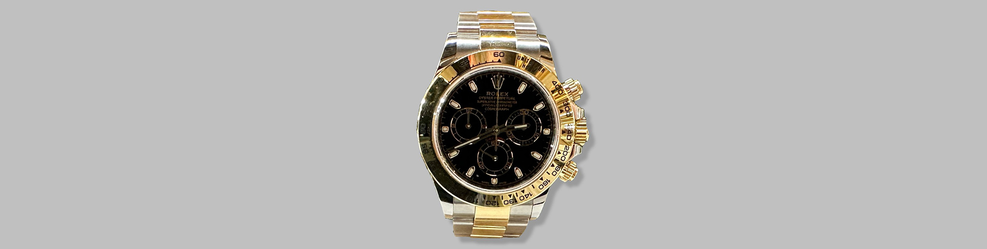 ne Rolex-Uhr mit schwarzem Zifferblatt und goldfarbenem Gehuse.