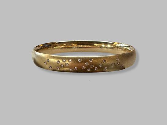 Ein goldener Ring mit kleinen Diamanten. Ein elegantes Schmuckstück für besondere Anlässe.